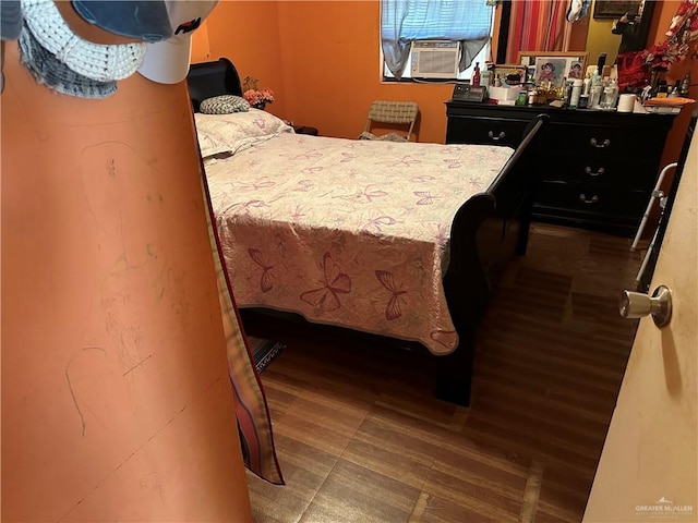 bedroom with cooling unit and wood-type flooring