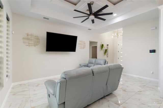 living room with ceiling fan with notable chandelier and a tray ceiling