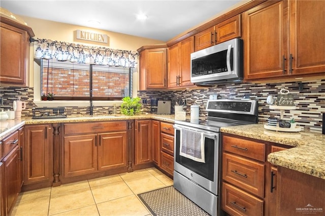 6800 N 15th Ln, Mcallen, TX 78504 - kitchen with stainless steel appliances, tasteful backsplash, light stone countertops, light tile patterned flooring, and brown cabinets
