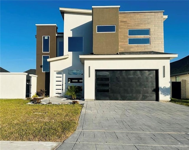 contemporary house featuring a garage and a front lawn