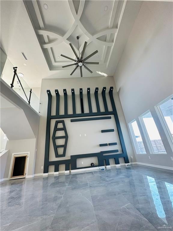 living room with coffered ceiling and a towering ceiling