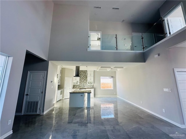 unfurnished living room featuring a high ceiling