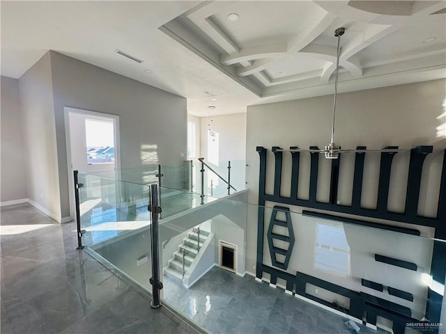 stairway with coffered ceiling and an inviting chandelier