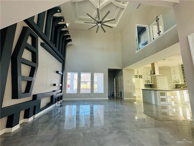 interior space with a high ceiling and ceiling fan