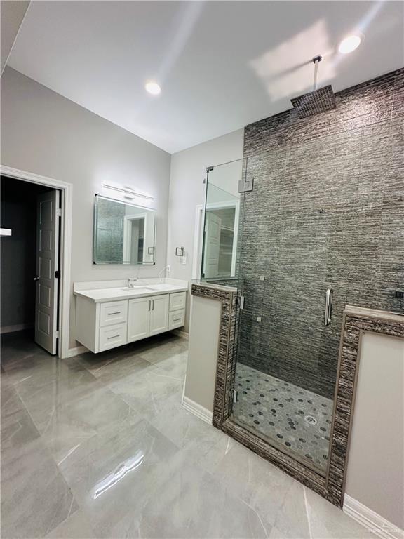 bathroom featuring vanity and a shower with door