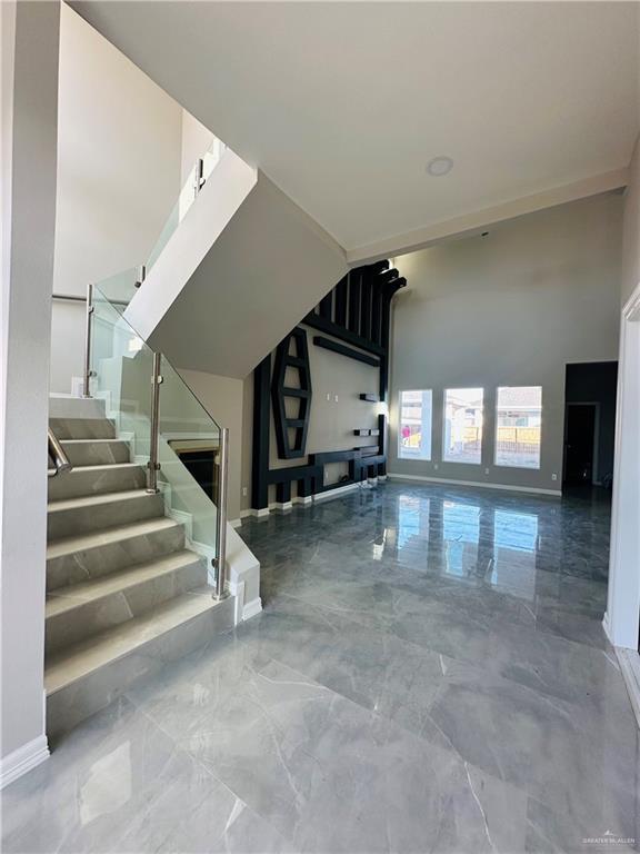 unfurnished living room with a towering ceiling