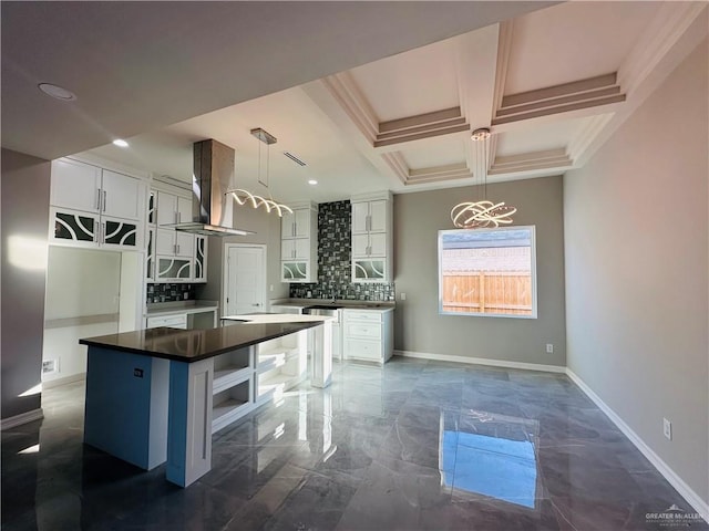 kitchen featuring coffered ceiling, extractor fan, decorative light fixtures, a kitchen island, and white cabinets