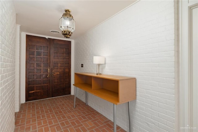 entrance foyer featuring brick wall