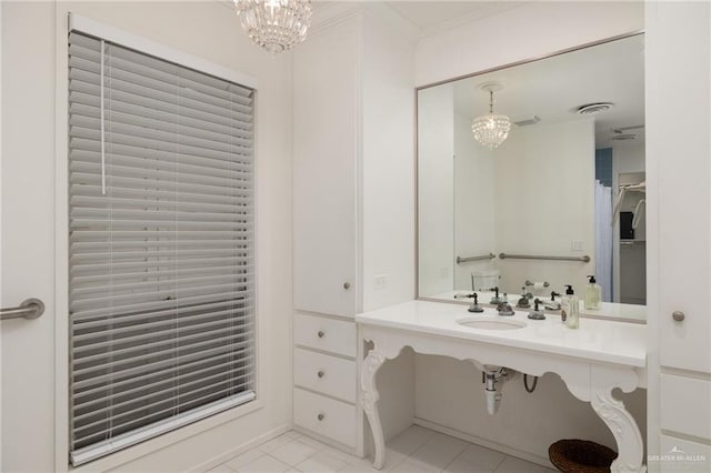 bathroom with sink, a notable chandelier, and tile patterned flooring