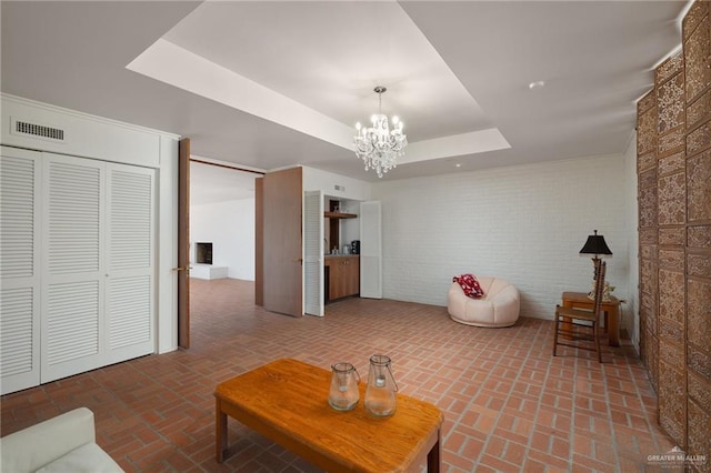 living room featuring a tray ceiling and a notable chandelier