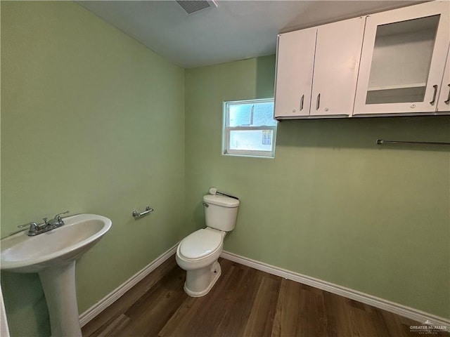 512 S 24th St, Donna, TX 78537 - bathroom featuring wood finished floors, toilet, baseboards, and a sink