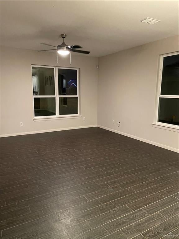empty room with dark hardwood / wood-style floors and ceiling fan