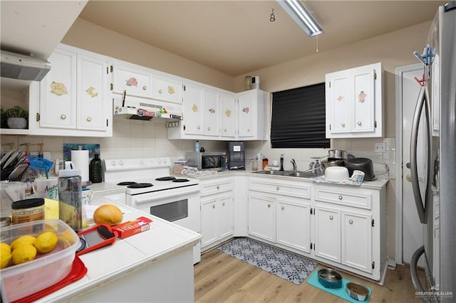 912 Bentsen Rd, Mcallen, TX 78501 - kitchen featuring stainless steel appliances, under cabinet range hood, white cabinetry, light countertops, and tasteful backsplash