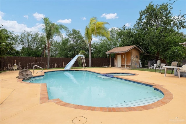 912 Bentsen Rd, Mcallen, TX 78501 - view of swimming pool with a fenced backyard, a water slide, a patio area, an outbuilding, and a storage shed