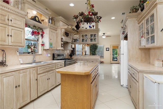 912 Bentsen Rd, Mcallen, TX 78501 - kitchen with stainless steel gas range, a sink, tile countertops, freestanding refrigerator, and recessed lighting
