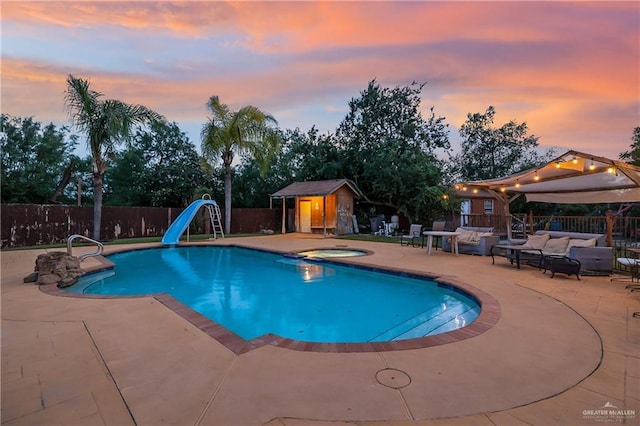 912 Bentsen Rd, Mcallen, TX 78501 - view of swimming pool with a water slide, a patio, an outdoor living space, a fenced backyard, and an in-ground hot tub
