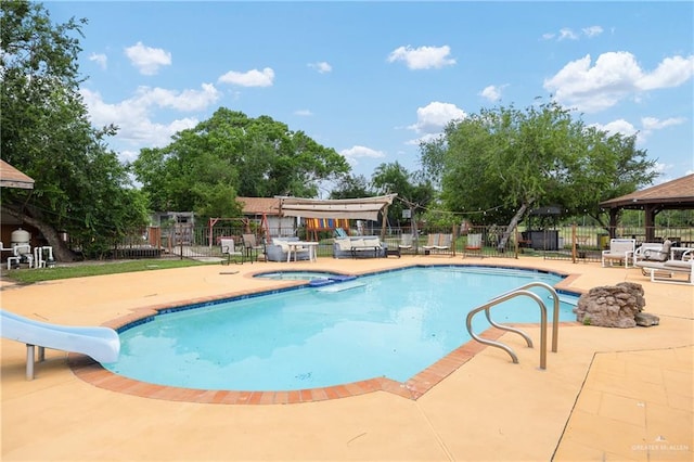 912 Bentsen Rd, Mcallen, TX 78501 - view of swimming pool with a gazebo, a water slide, a patio, fence, and a pool with connected hot tub