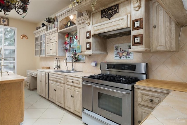 912 Bentsen Rd, Mcallen, TX 78501 - kitchen featuring double oven range, tile counters, a sink, light tile patterned flooring, and decorative backsplash