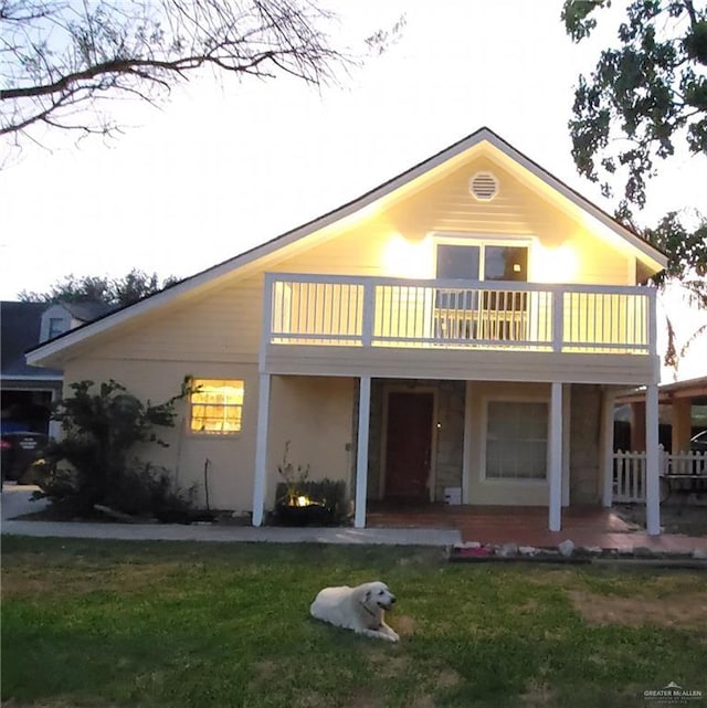 1405 S Brier St, Alton, TX 78573 - rear view of house featuring a balcony, covered porch, and a lawn
