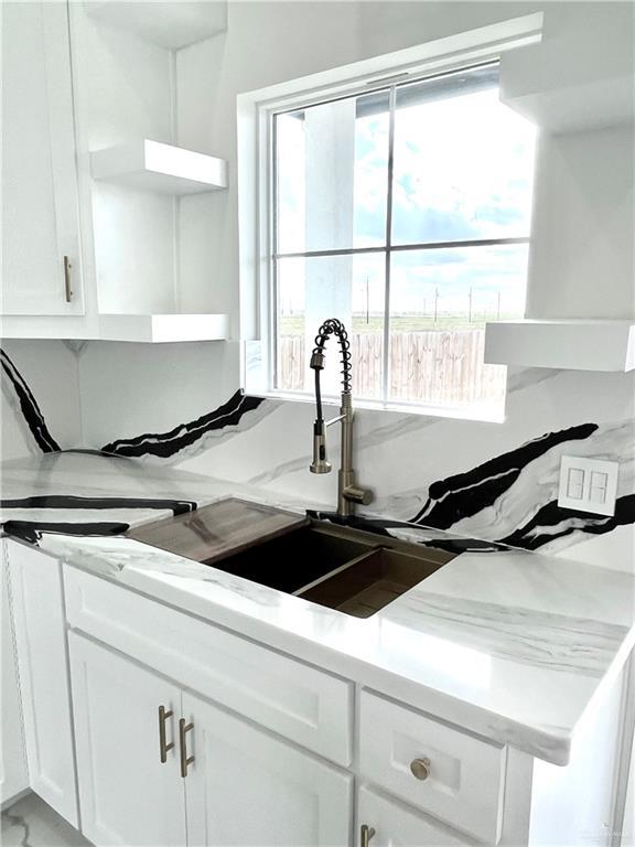 kitchen featuring sink and white cabinets