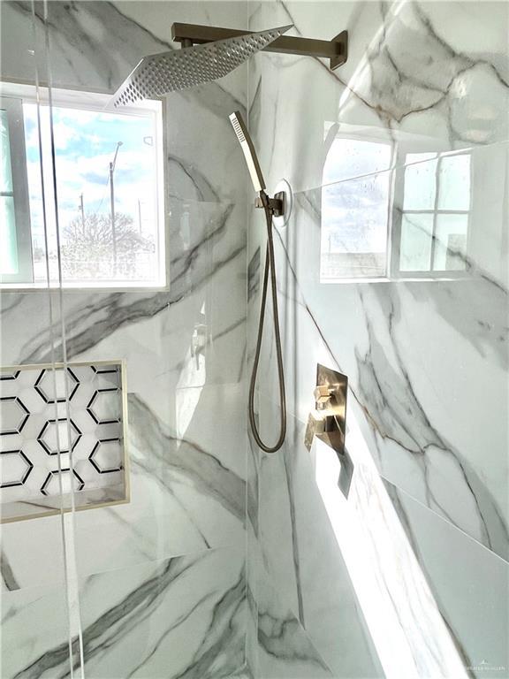 interior details featuring tiled shower