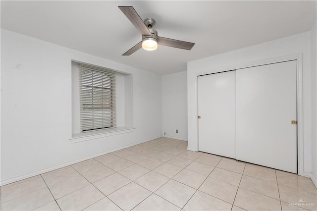 unfurnished bedroom with a closet, ceiling fan, and light tile patterned flooring