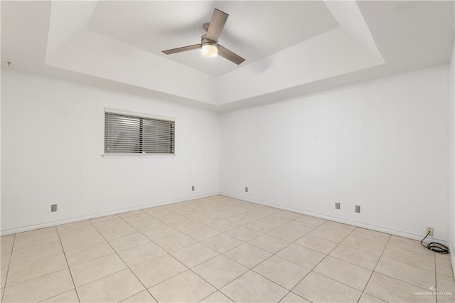 spare room featuring a raised ceiling and ceiling fan