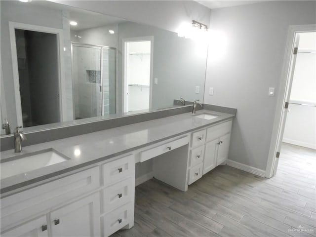 bathroom with hardwood / wood-style floors, vanity, and walk in shower