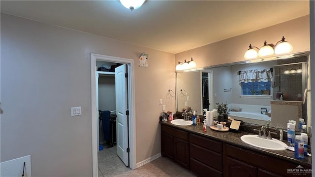 bathroom featuring tile patterned flooring, vanity, and a washtub