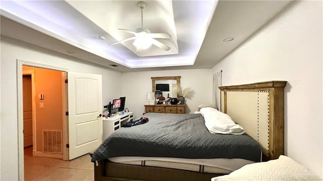 bedroom featuring a raised ceiling and ceiling fan