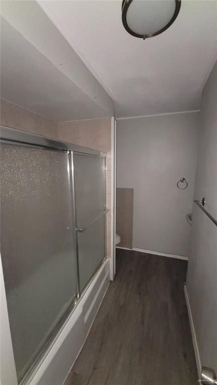 1600 Bridge Ave Unit 207, Weslaco, TX 78596 - full bathroom featuring wood finished floors, toilet, bath / shower combo with glass door, and baseboards