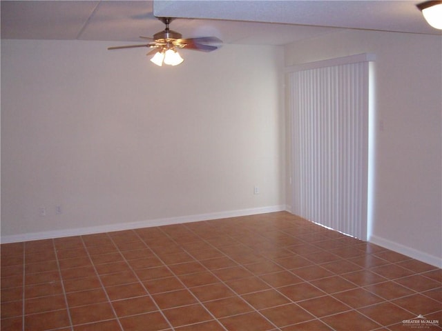 empty room featuring ceiling fan and dark tile patterned floors