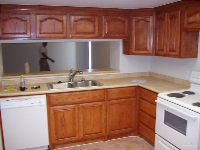 kitchen with white appliances, sink, and light tile patterned floors