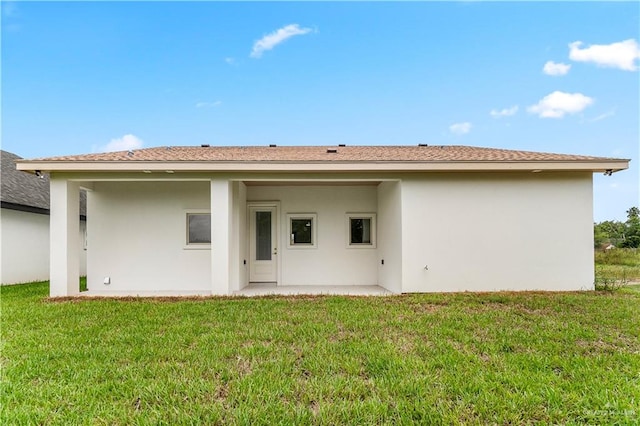 rear view of property with a patio and a lawn