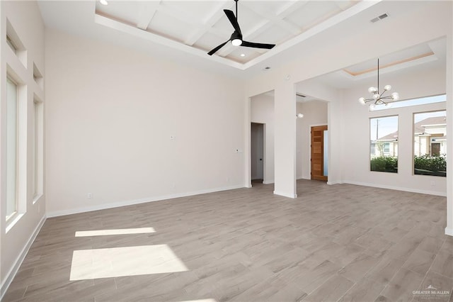 unfurnished living room with beamed ceiling, light hardwood / wood-style flooring, ceiling fan with notable chandelier, and coffered ceiling