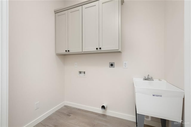 laundry area featuring sink, cabinets, washer hookup, electric dryer hookup, and light wood-type flooring