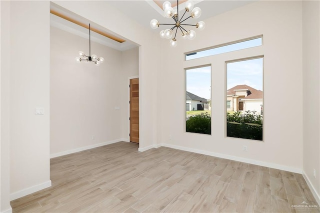 unfurnished room featuring light hardwood / wood-style floors and an inviting chandelier