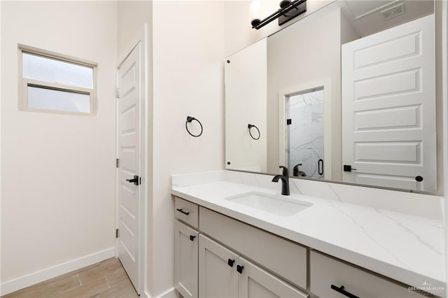 bathroom with hardwood / wood-style floors, vanity, and a shower with door