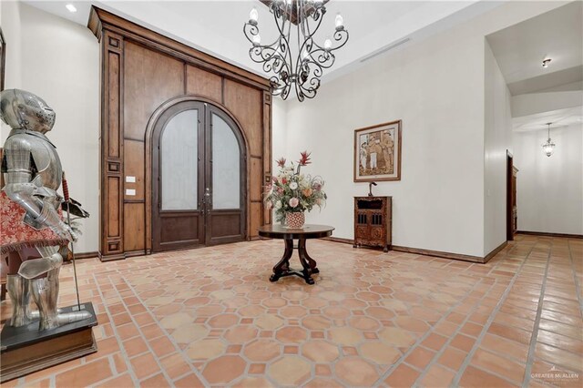 foyer with baseboards, a chandelier, and visible vents
