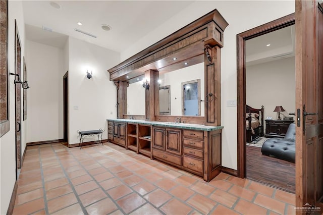 full bath with tile patterned floors, visible vents, double vanity, and a sink
