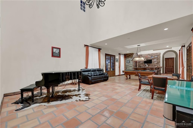interior space featuring recessed lighting, tile patterned floors, a towering ceiling, arched walkways, and billiards