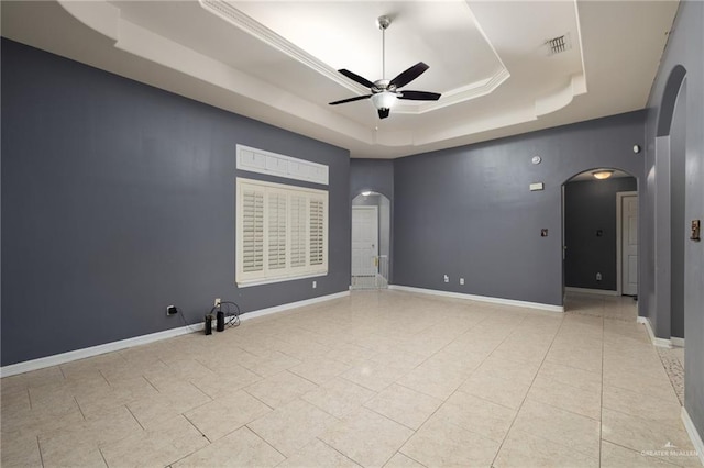 spare room with ornamental molding, light tile patterned floors, ceiling fan, and a tray ceiling