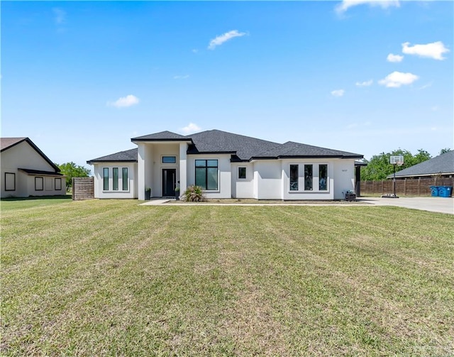 rear view of property featuring french doors, stucco siding, fence, and a yard