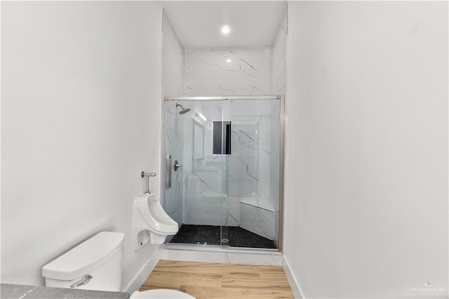 full bath featuring a marble finish shower, baseboards, toilet, and wood finished floors