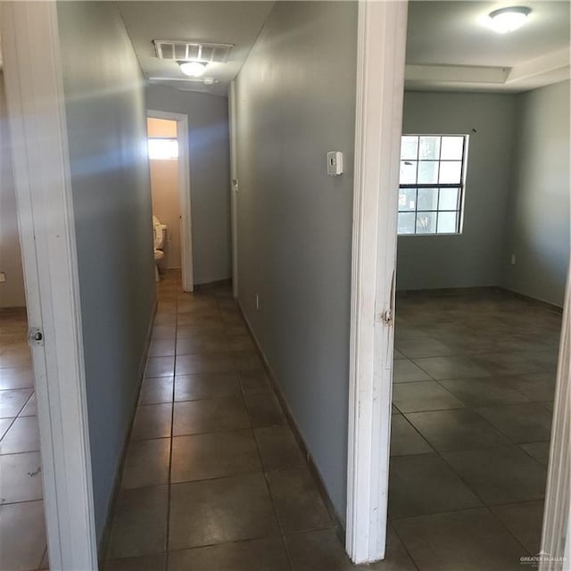 corridor with dark tile patterned flooring