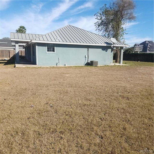 view of side of home featuring central air condition unit and a lawn