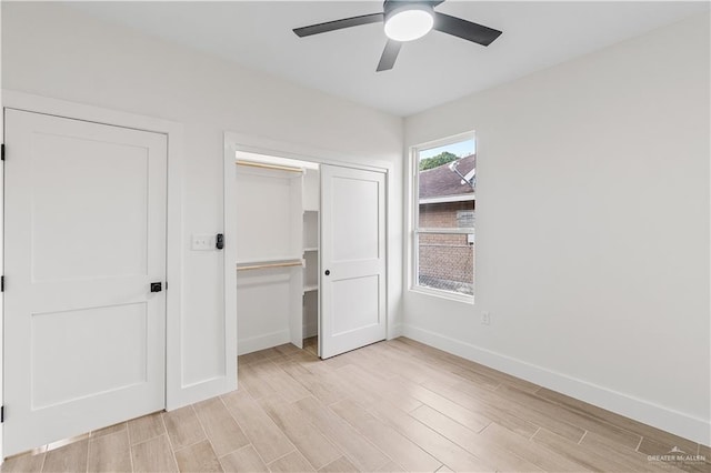 unfurnished bedroom featuring a closet, a ceiling fan, light wood-type flooring, and baseboards