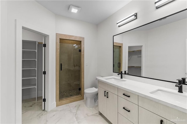 bathroom featuring a sink, toilet, marble finish floor, and a stall shower