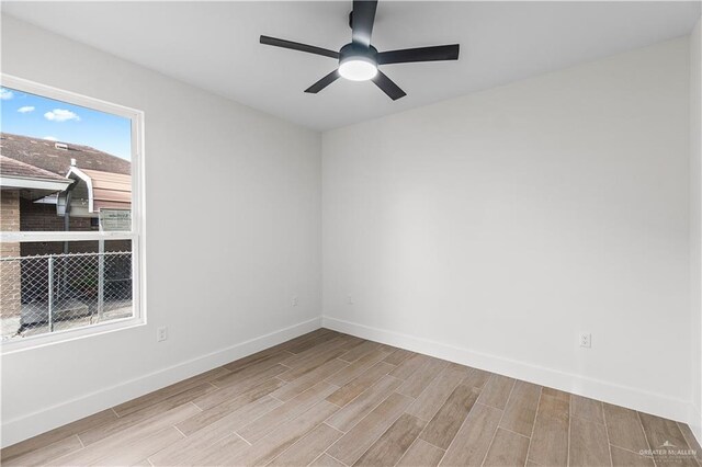 unfurnished room with ceiling fan, baseboards, and wood tiled floor