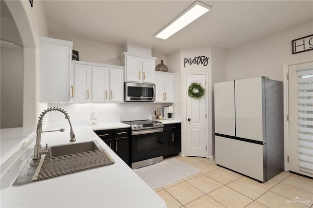 3517 Prestwick St, Edinburg, TX 78542 - kitchen featuring appliances with stainless steel finishes, white cabinetry, light countertops, light tile patterned floors, and arched walkways